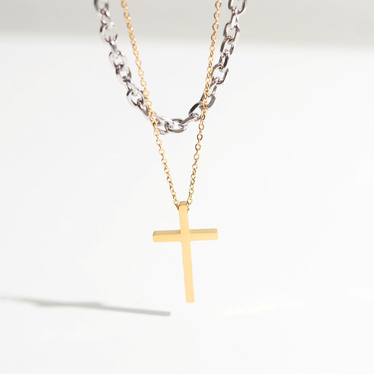 Cross pendant stacked with titanium steel necklace