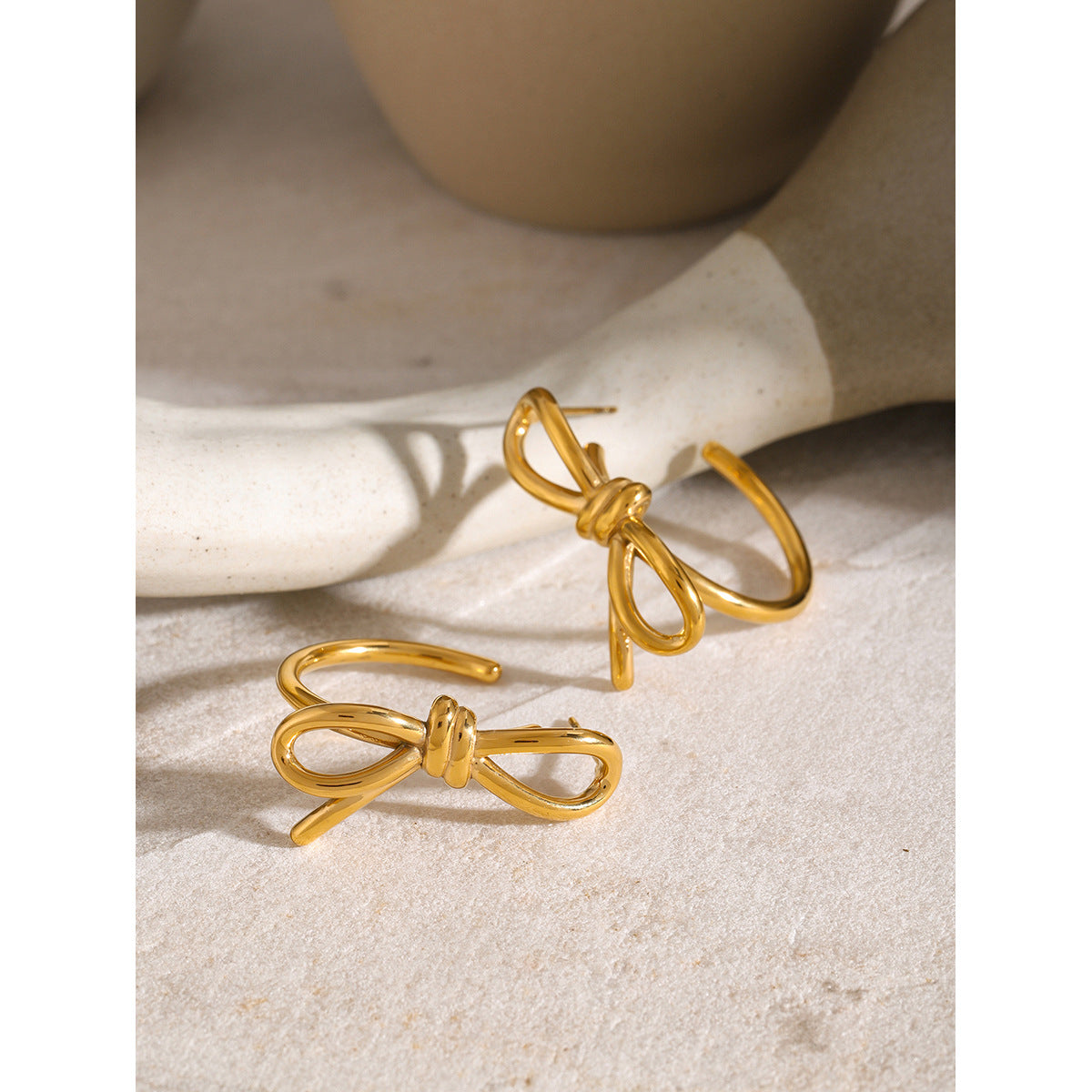 Linear bow C-shaped earrings