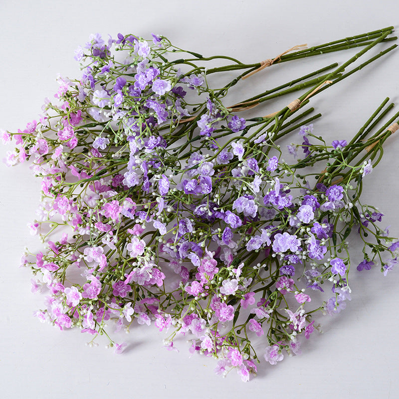 Holding a simulated bouquet of baby's breath