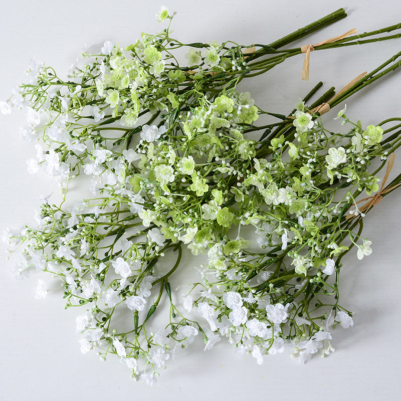 Holding a simulated bouquet of baby's breath