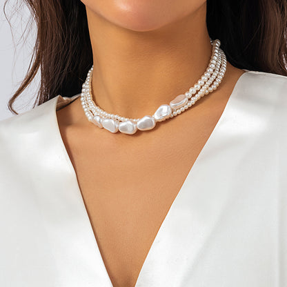 Imitation pearls stacked with woven baroque necklaces