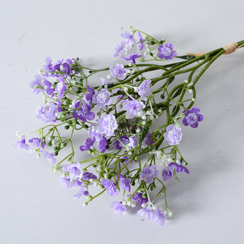 Holding a simulated bouquet of baby's breath