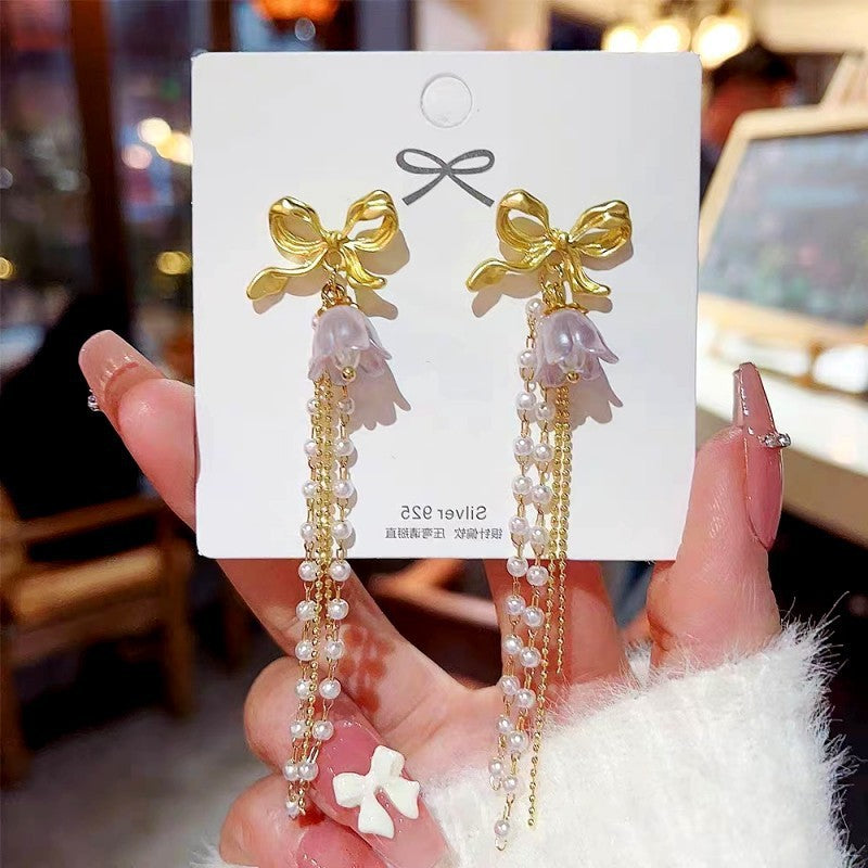 Long bow pearl fringed earrings.