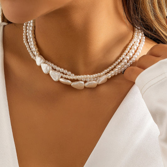 Imitation pearls stacked with woven baroque necklaces