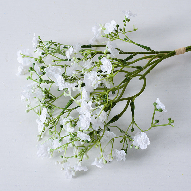 Holding a simulated bouquet of baby's breath