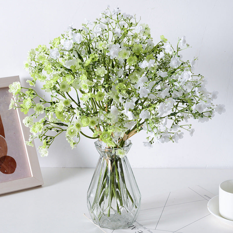 Holding a simulated bouquet of baby's breath