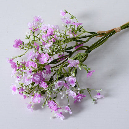 Holding a simulated bouquet of baby's breath