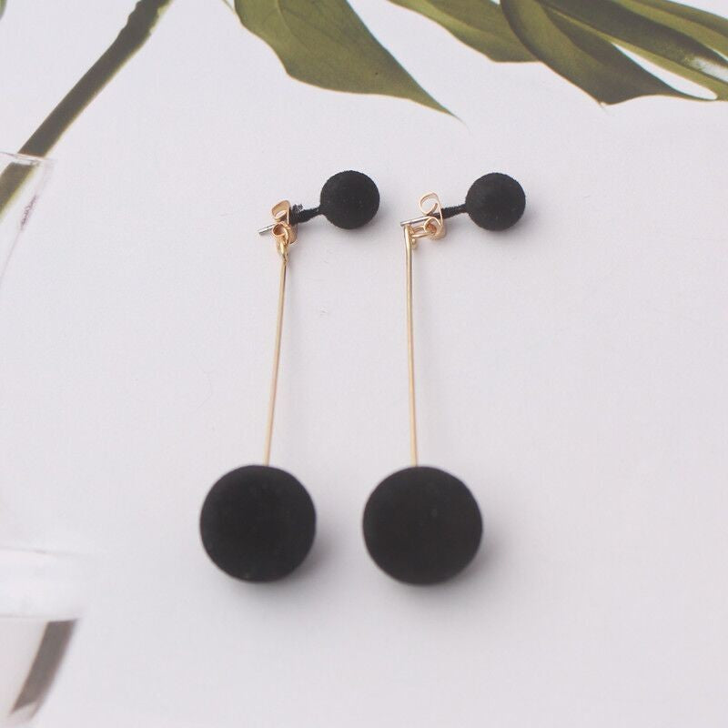 Large and small pom-pom long stud earrings.