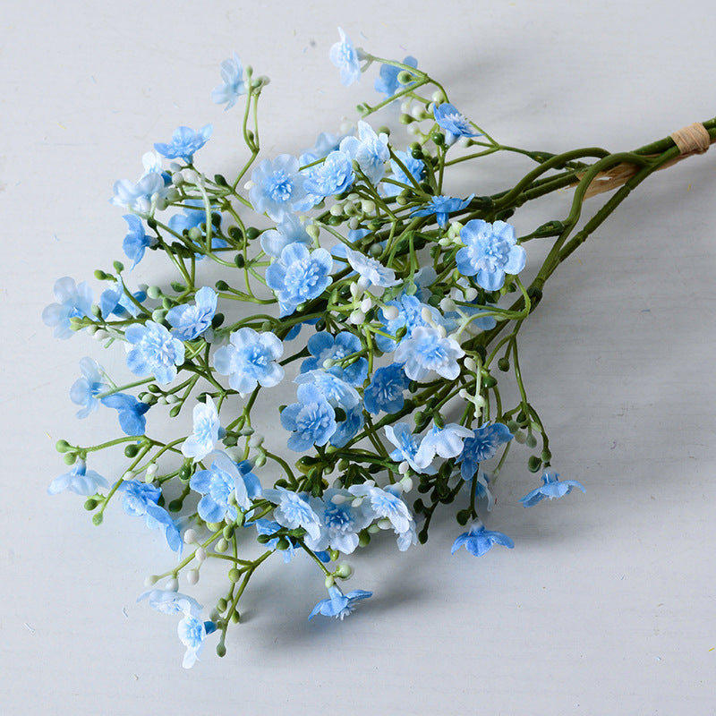 Holding a simulated bouquet of baby's breath