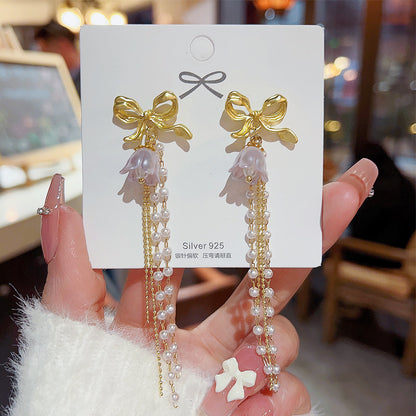 Long bow pearl fringed earrings.