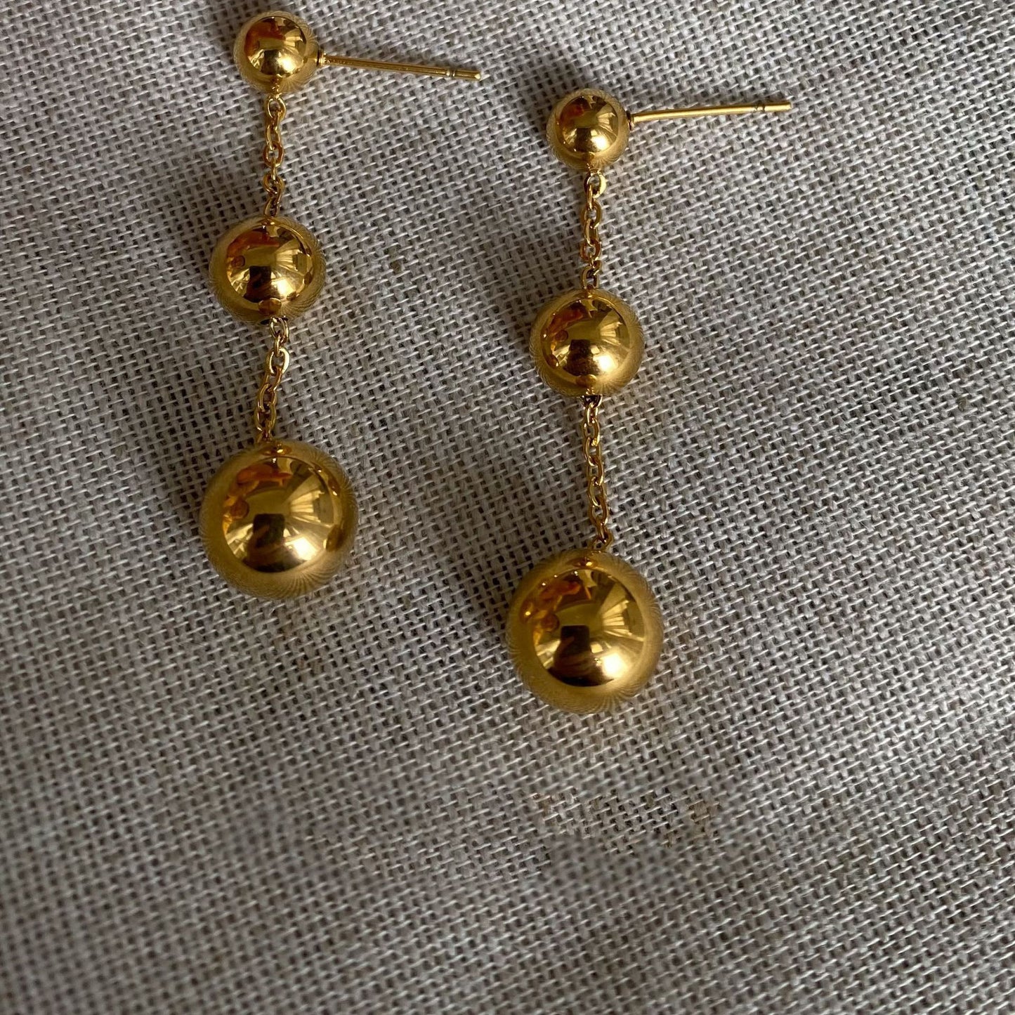 Three gold bead fringed earrings.