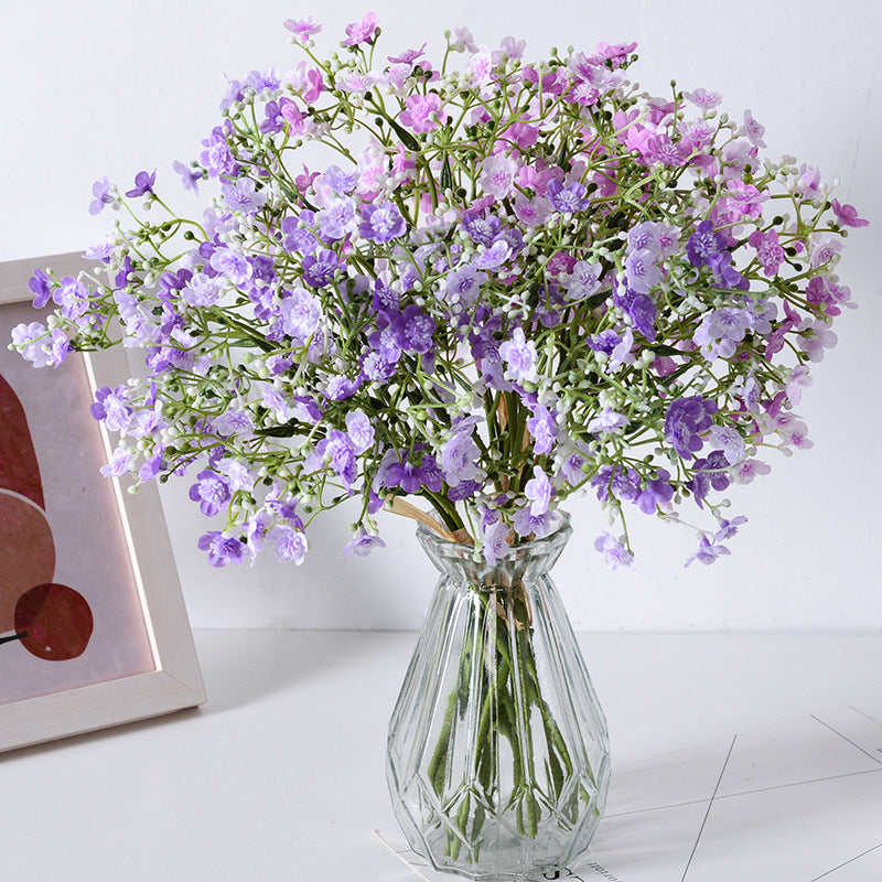 Holding a simulated bouquet of baby's breath