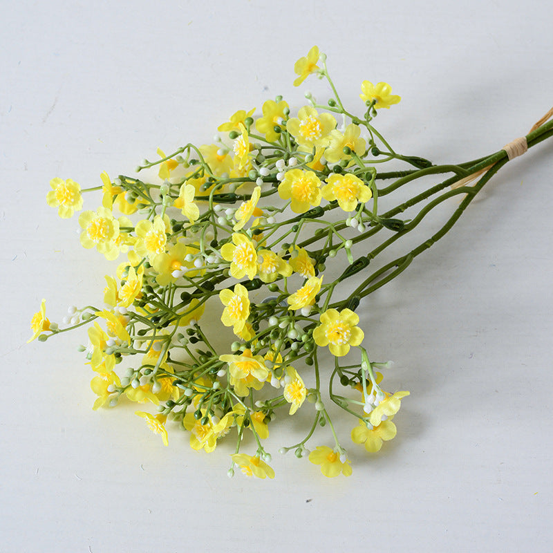 Holding a simulated bouquet of baby's breath